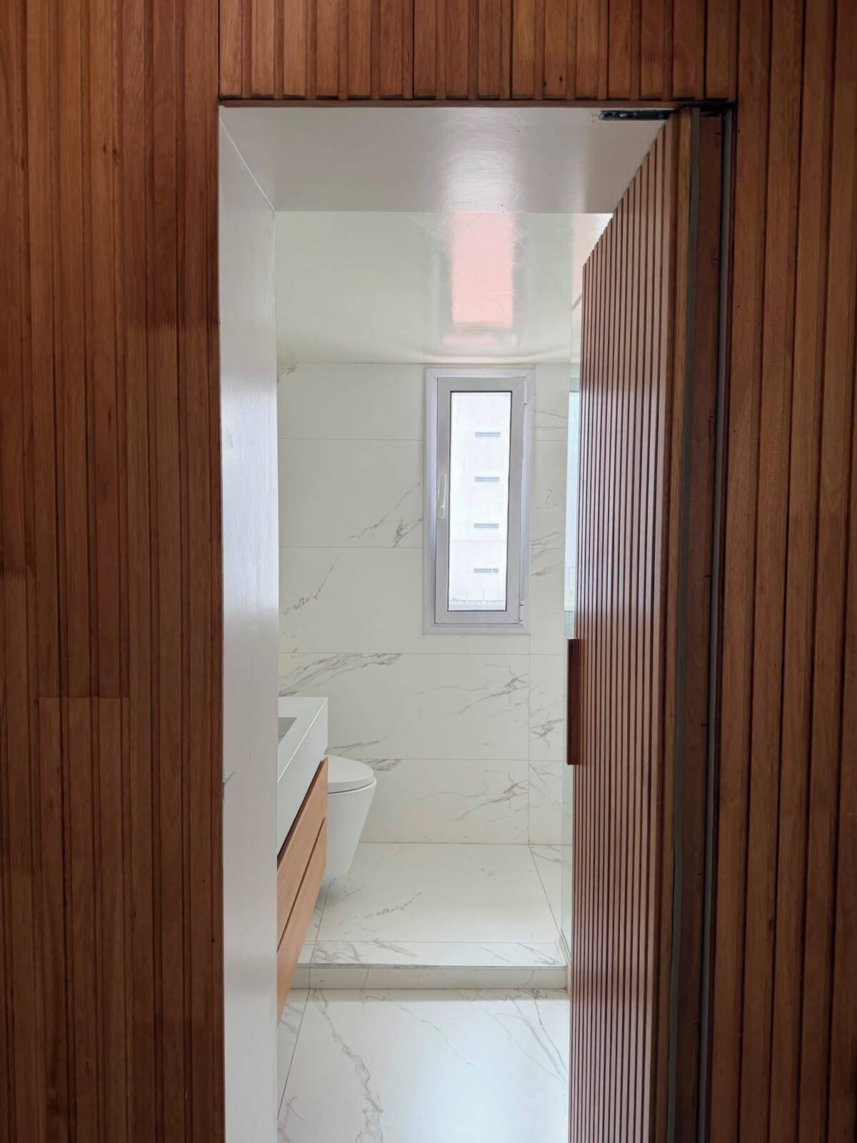 Ein Badezimmer mit Toilette, Waschbecken und einem Fenster.
