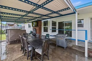 An outdoor patio with a grill, dining table, and chairs. - Your Riverside Retreat. (Riverside)