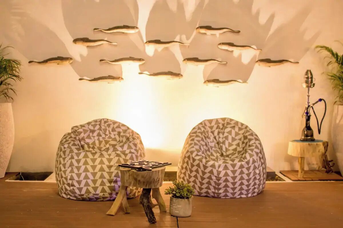 A cozy seating area with two bean bag chairs, a small wooden table, and a wall-mounted light fixture.