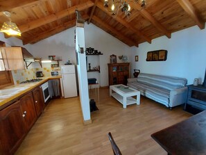 A compact kitchen with wooden cabinets, a refrigerator, and a microwave. - A House with Beautiful Sunrises (El rosario)