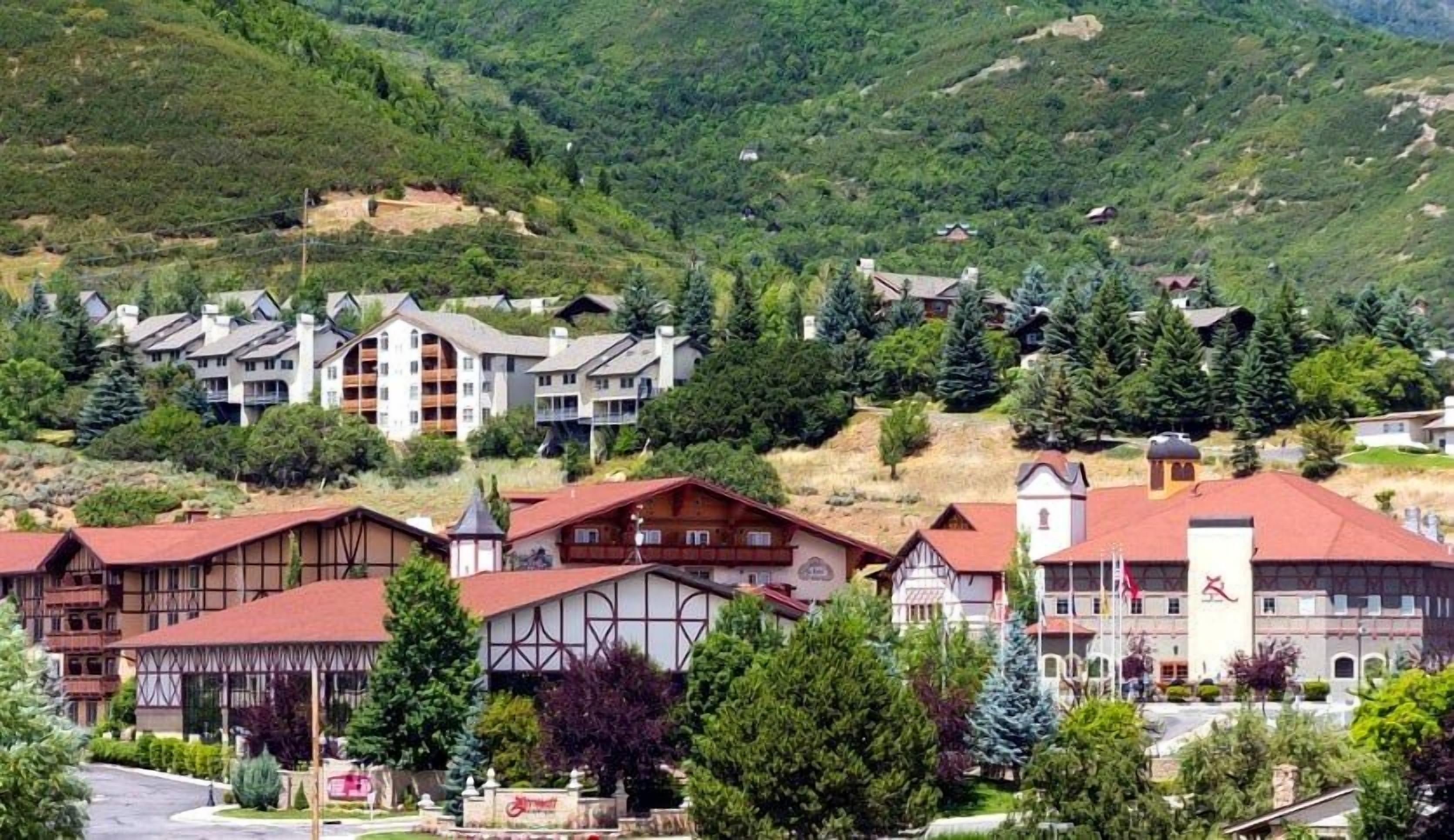 Ein Hotel mit traditioneller Architektur, mehreren Etagen und einer Bergkulisse im Hintergrund.