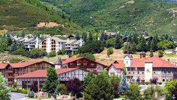 Ein Hotel mit traditioneller Architektur, mehreren Etagen und einer Bergkulisse im Hintergrund.