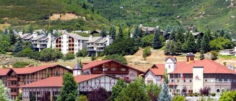 Un hotel de arquitectura tradicional, con varios pisos y montañas al fondo.