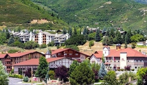 A hotel with traditional architecture, multiple floors, and a mountainous backdrop.
