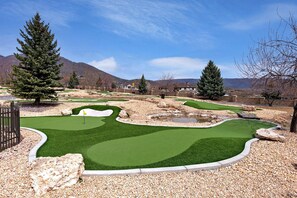 A miniature golf course with a green fairway, sand traps, and a flagstick.