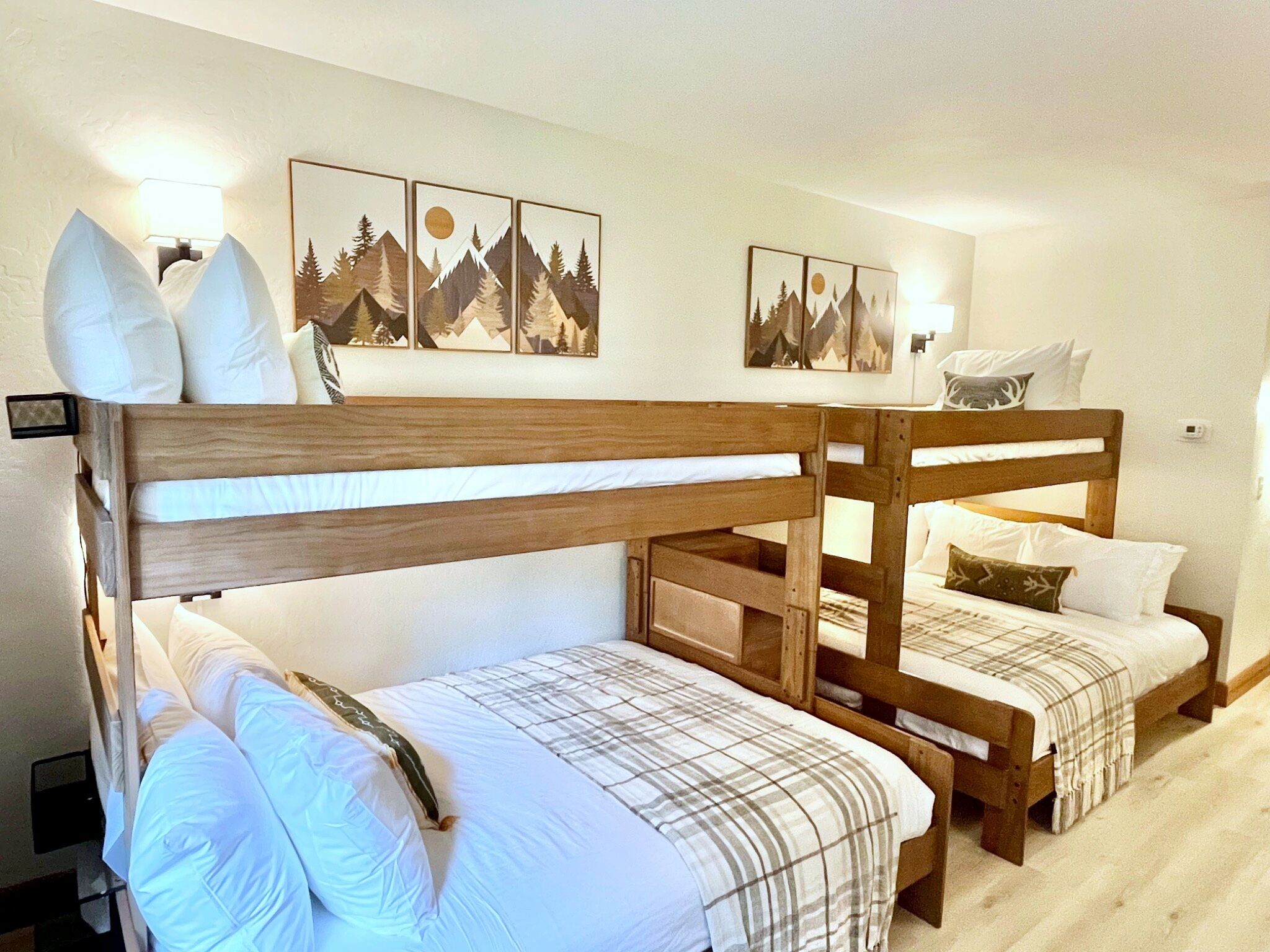 Ein Zimmer mit zwei Etagenbetten, einem Nachttisch und Wandleuchten.