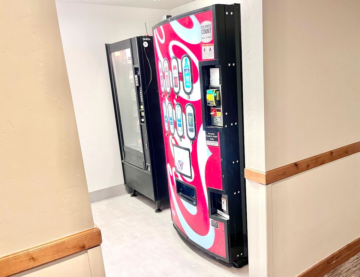 A hallway with vending machines and a door.