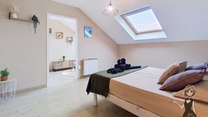 A bedroom with a skylight, a bed with pillows, a bedside table, and a hanging plant. - The Tarbaise Canopy • Patio, tranquility & coziness (Tarbes)