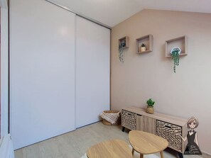 A modern room with a sliding door, a small table, a bench, a wooden console, and wall-mounted shelves with plants.