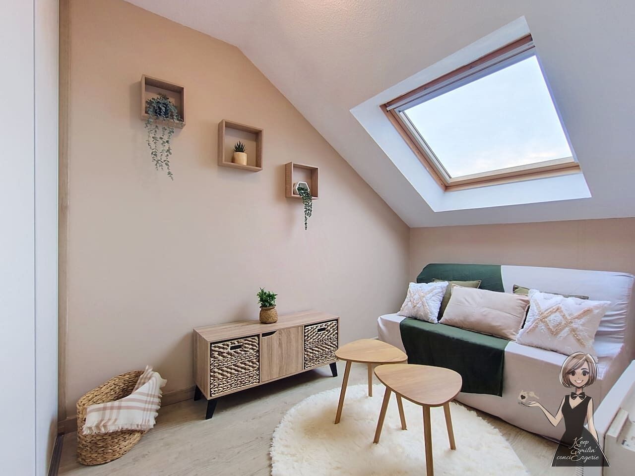 A cozy room with a sloped ceiling, a skylight, a sofa, a small table, and a cabinet.
