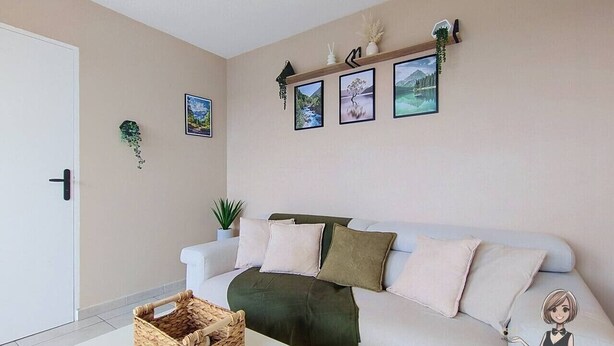 A living room with a white sofa, a coffee table, and a basket. There are framed pictures on the wall and a plant on the sofa. - The Tarbaise Canopy • Patio, tranquility & coziness (Tarbes)