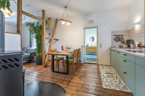 Una cocina moderna con suelo de madera, un comedor con mesa y sillas de madera, y una encimera de cocina con armarios.