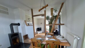 Ein Essbereich mit Holztisch, Stühlen, Kamin und Heizkörper.