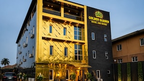 Un hotel con un letrero llamativo que dice 'Golden Garden Hotel and Suites'.
