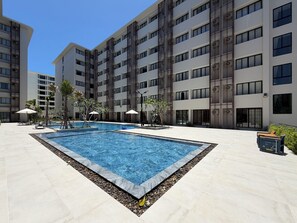 A modern hotel with a swimming pool, outdoor seating, and a well-maintained garden area. - Utopia Dream U2 Prestige Suites & Pool (Mueang Phuket)