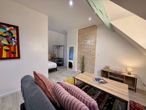 Una camera da letto moderna in stile loft con soffitto spiovente, un letto, una scrivania e una sedia.