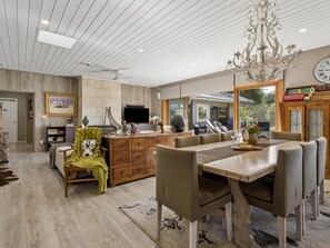 A spacious living area with a dining table, comfortable seating, a large mirror, and a chandelier. - Solhaven Sorrento Pool and Tennis Retreat (Sorrento)
