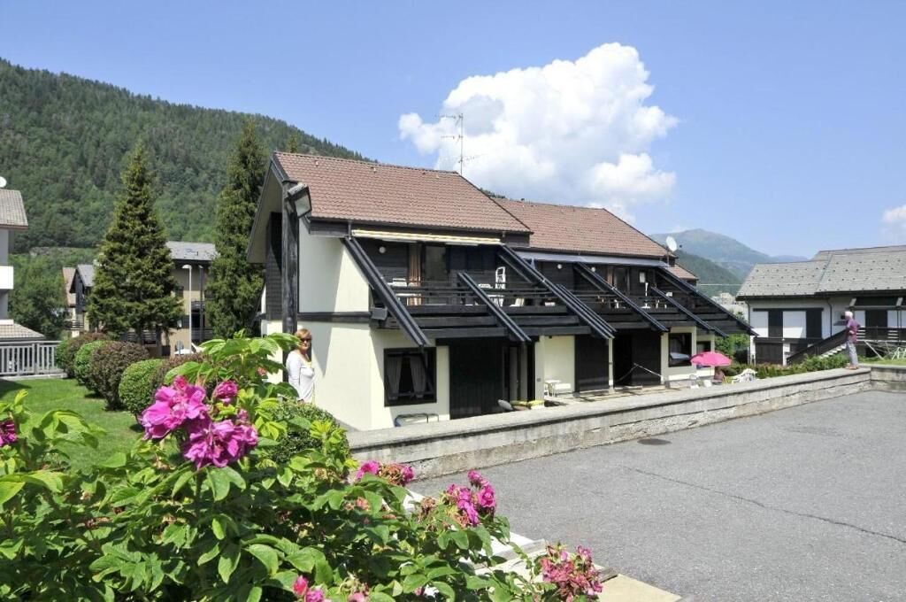 Un hotel con techo inclinado, un espacio de estar cubierto al aire libre y vistas a la montaña.