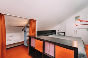 Quarto estilo dormitório com beliche, escrivaninha e cadeira.