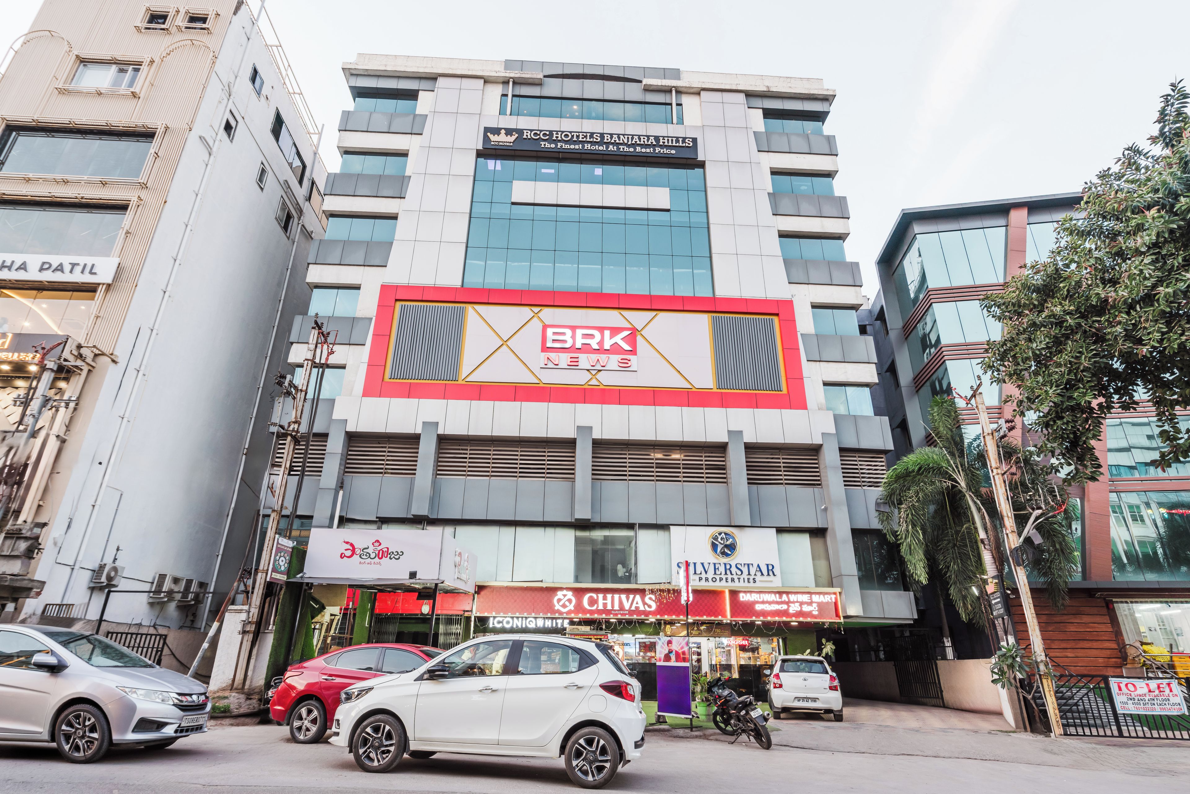 Un edificio de varios pisos con un llamativo letrero de BRK News, un restaurante llamado 'Chivas' y un anuncio de 'Silverstar Properties'.