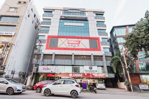 Um edifício com vários andares, com uma placa de destaque da BRK News, um restaurante chamado 'Chivas' e uma placa da 'Silverstar Properties'.