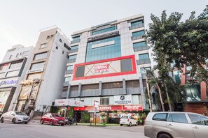 Un immeuble à plusieurs étages, sur lequel on peut voir une grande enseigne annonçant un hôtel de la chaîne BRK New, ainsi qu’un restaurant appelé ICONIQWINITE et une boutique de vins.