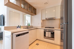 Een moderne keuken met een vaatwasser, oven en roestvrijstalen apparatuur.