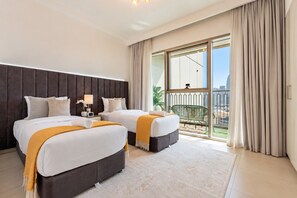 Een hotelkamer met twee bedden, een groot raam met gordijnen, een balkon en uitzicht op de stad.