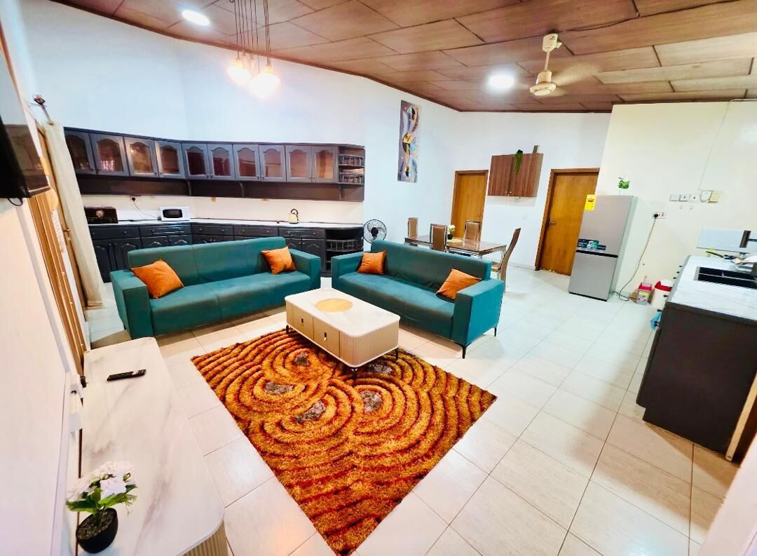 A living room with a sofa set, a coffee table, and a patterned rug.
