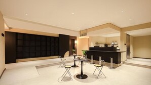 A modern interior with a reception desk, seating area, and a black partition wall.