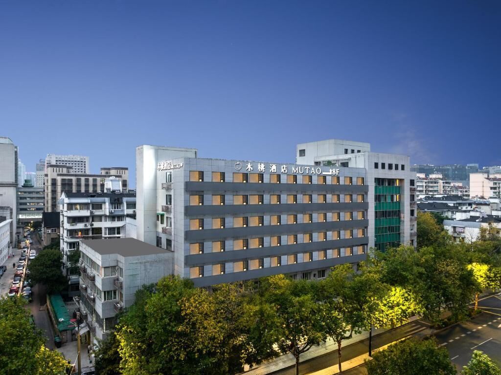 A multi-story hotel building with a modern facade, multiple windows, and a sign indicating its name.