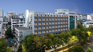 A multi-story hotel building with a modern facade, multiple windows, and a sign indicating its name.