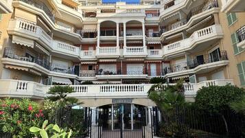 A multi-story residential building with balconies, a gated entrance, and a sign indicating 'VICTORIA BEACH'.