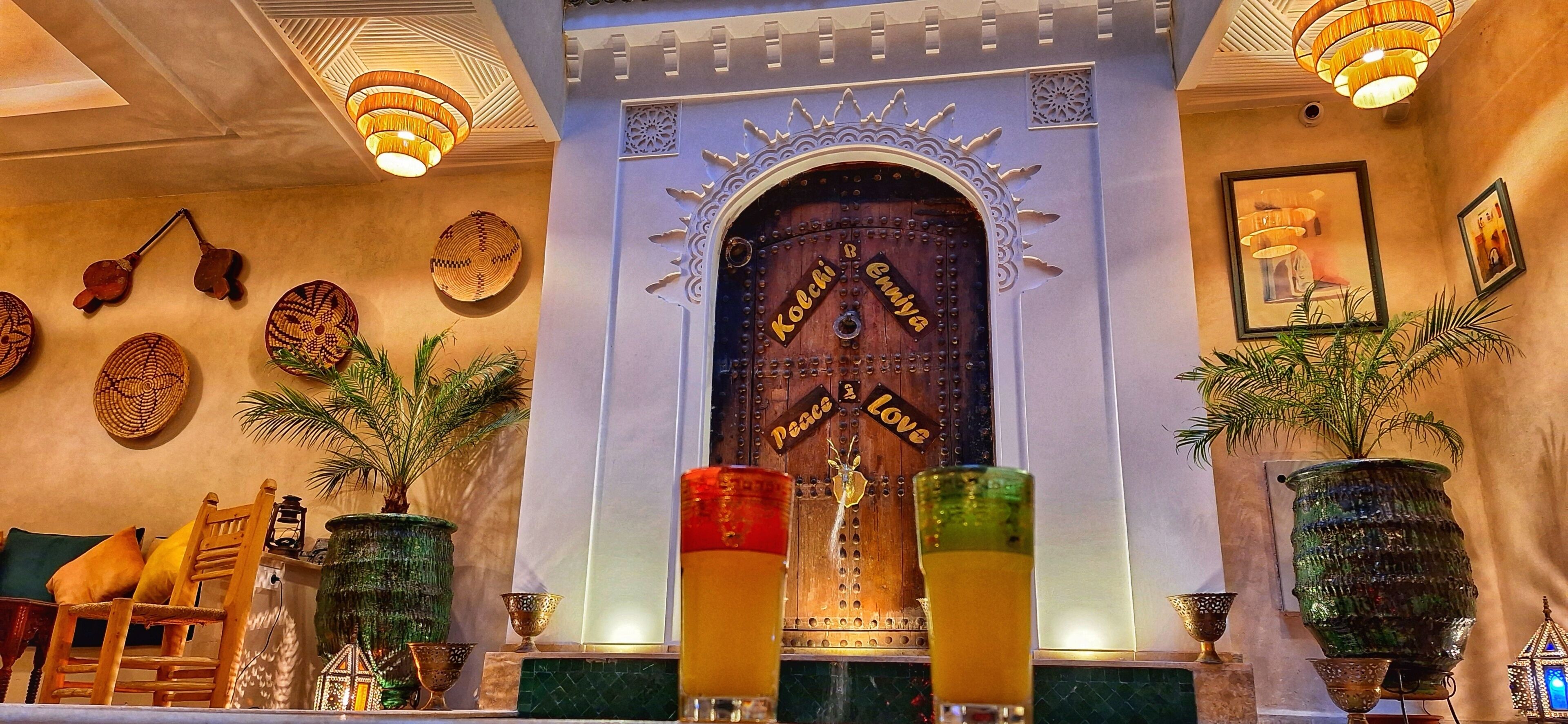 A bar area with a decorative door, wall-mounted baskets, and a variety of glassware.