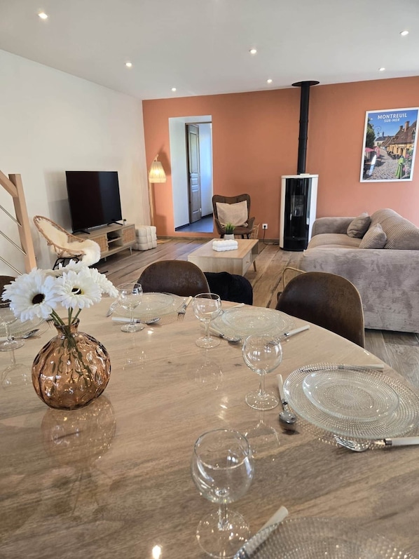 A dining area with a table set for four, a television, and a poster on the wall. - Montr'oeil d'Opale (Écuires)