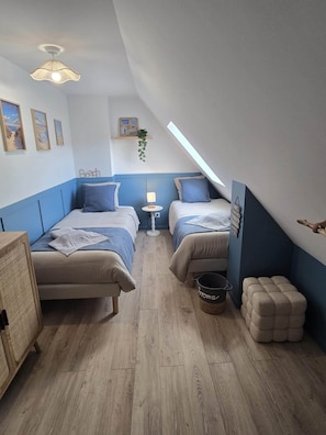 A bedroom with two beds, a bedside table, a hanging plant, and a small stool. - Montr'oeil d'Opale (Écuires)