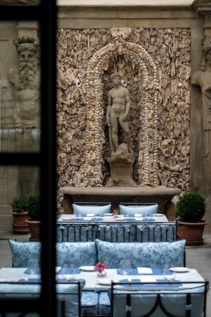 A stone statue of a male figure in a niche, surrounded by a textured stone wall with a rough, natural appearance. - Palazzo Sogni (Florence)