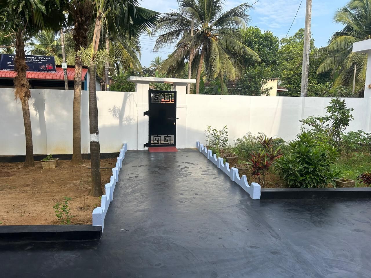 A gated entrance with a concrete pathway leading to a building.