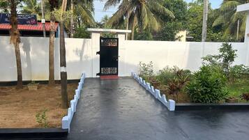 A gated entrance with a concrete pathway leading to a building.