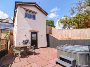 Eine Terrasse mit Whirlpool, Tisch und Stühlen.