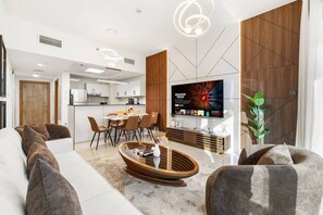 Ein modernes Wohnzimmer mit einer Couch, einem Couchtisch und einem an der Wand montierten Fernseher.