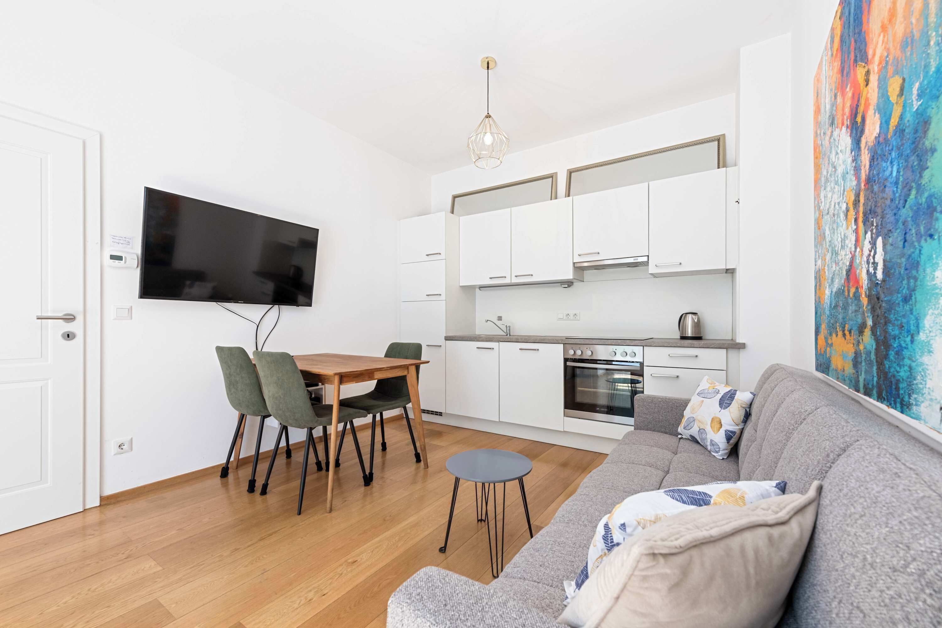 Un apartamento moderno con comedor, kitchenette y sala de estar.