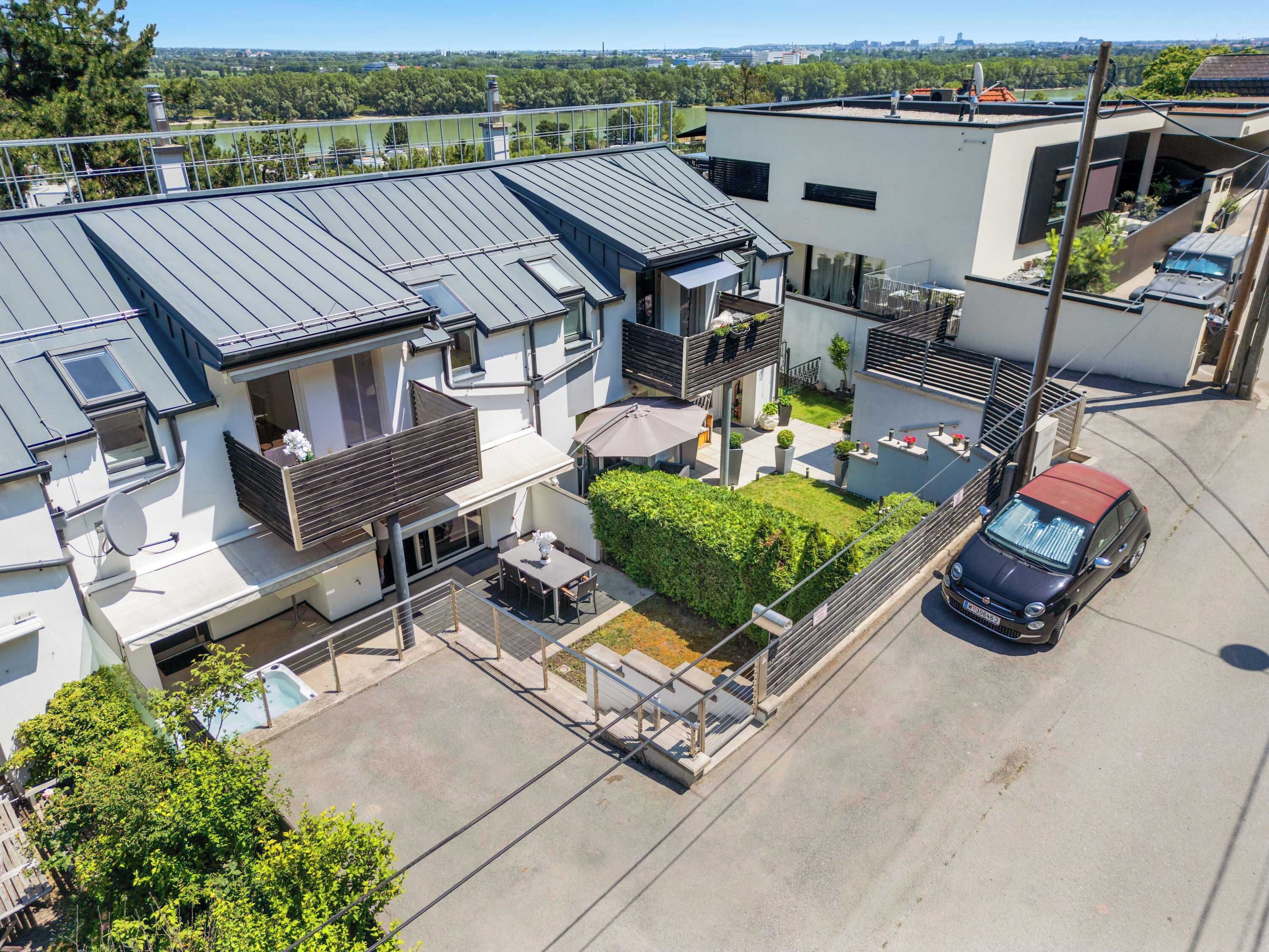 Un quartier résidentiel avec des maisons modernes, une piscine et une voiture garée.