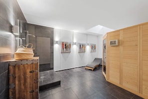 Een moderne spa-ruimte met een houten kast, een bankje en kunst aan de wanden.
