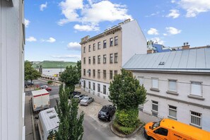 A multi-story building with a flat roof and a parking area in front. - AufLeeben Vienna | Kitchen | King-Size | Metro (Wien)