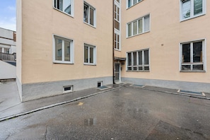 Ein mehrstöckiges Gebäude mit einer flachen Fassade, zahlreichen Fenstern und einem zentralen Eingang.