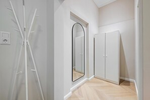 A hallway with a white wardrobe, a mirror, and a white radiator. - Kaiser 1BR | Metro & Tram | Nespresso | Central (Wien)