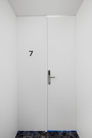 A white door with a number '7' and a modern door handle. - Kaiser Room | King Bed | Metro & Tram (Wien)