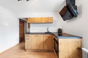 Una cucina moderna con mobili in legno, una cappa aspirante nera e un forno integrato.