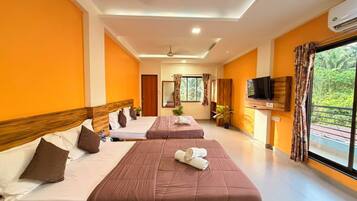 A hotel room with two beds, a television, and a window with curtains.